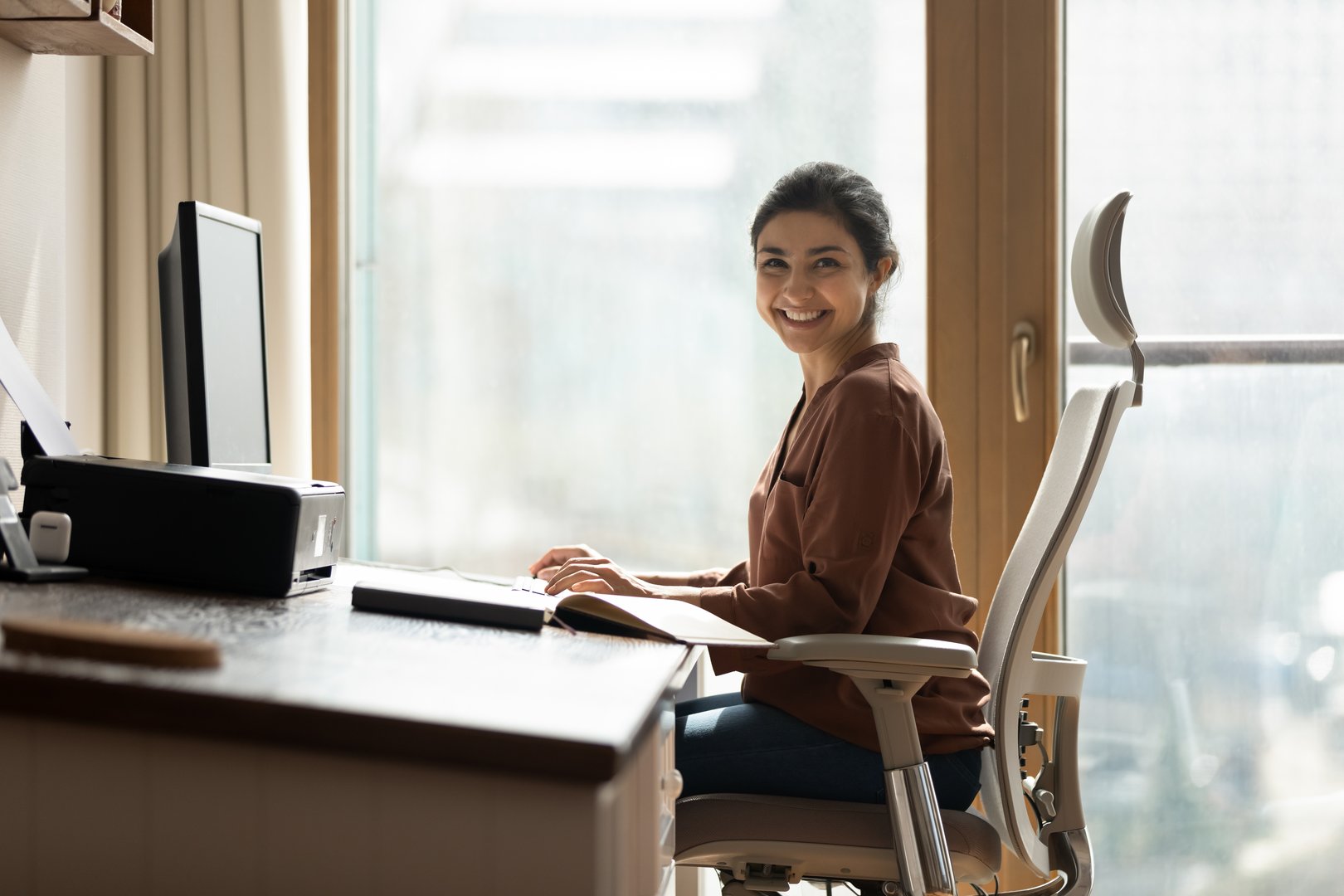 Modern day worker smiling at computer